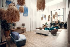 Lobby des Views Oasis Hotels mit Holzboden, weißen Wänden und blauen Möbeln.