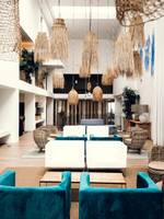 Lobby des Views Oasis Hotels mit weißen Möbeln, blauen Kissen und rustikalen Hängelampen.