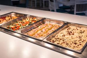 Buffet-Tisch im Views Oasis Hotel mit verschiedenen Gerichten wie Salat, Fleisch und Reis.