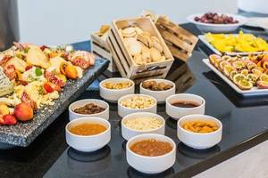 Buffettisch mit Käse, Obst und Getränken im The Views Oasis Hotel.