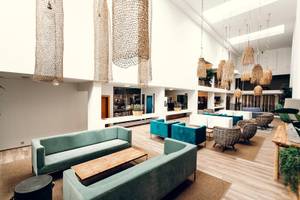 Lobby des Views Oasis Hotels mit modernen Möbeln, Holzböden und hängenden Lampen.