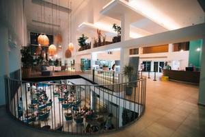 Innenansicht des The Views Oasis Hotel mit mehreren Stockwerken, Sitzbereichen und Pflanzen.