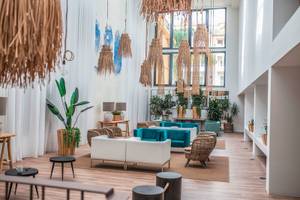 Innenansicht der geräumigen Lobby des Views Oasis Hotels mit weißen Wänden, Holzboden und modernen Möbeln.