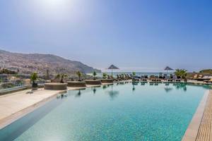 Obere Ansicht des Pools im The Views Baia Hotel mit Sonnenliegen und Blick auf das Meer und die Stadt.
