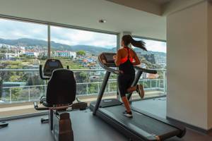 Frau im Fitnessraum des Hotels The Views Baia, die auf einem Laufband läuft