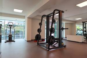 Fitnessstudio im The Views Baia Hotel mit Geräten und Ausblick auf die Stadt.