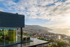 Aussicht von der Terrasse des Views Baia Hotels bei Sonnenuntergang mit Blick auf die Stadt und das Meer.