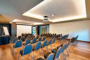 Konferenzraum im Views Baia Hotel mit blauen Stühlen und einer Leinwand.