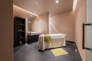 Das Innere des Wellnessbereichs im The Views Baia Hotel mit einer Massageliege und einem Waschbecken.