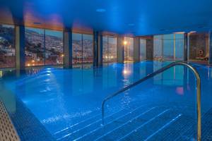 Innenpool des The Views Baia Hotels mit blauen Lichtern und Stadtblick