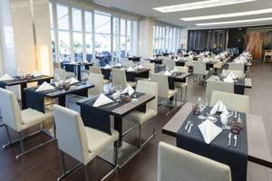 Restaurant des Melia Madeira Mare Resort & Spa mit gedeckten Tischen und Stühlen