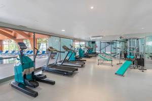 Fitnessraum im Royal Savoy Hotel mit moderner Trainingsgeräten und blauen Liegebänken.