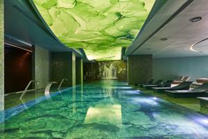 Wasserwelt im Savoy Palace Hotel mit grüner Decke und Wasserfallprojektion.