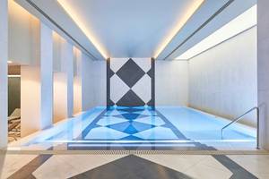 Innenpool des Savoy Palace Hotels mit blauen Wasser und geometrischem Bodendesign.