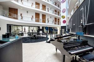 Lobby des Aqua Pedra dos Bicos Hotels mit Klavier und Sitzbereich.