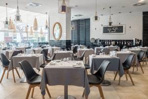 Restaurant des Aqua Pedra dos Bicos Hotels mit gedeckten Tischen und Stühlen.