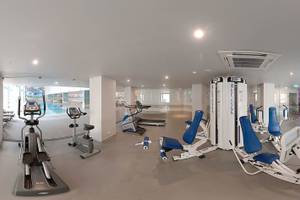 Fitnesscenter im Vila Galé Cerro Alagoa Hotel mit verschiedenen Trainingsgeräten und Blick auf den Pool.