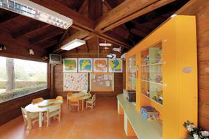 Kinderzimmer im Vila Galé Cerro Alagoa Hotel mit gelben Möbeln und bunten Wandbildern.