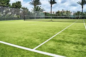 Tennisplatz im Falesia Hotel - Algarve mit grünem Kunstrasen und weißem Rand.