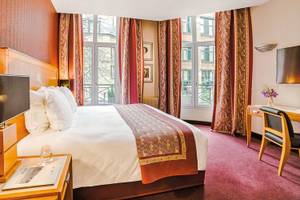 Schlafzimmer des Les Jardins du Marais Hotels mit großem Bett, Fenstern und Dekor.