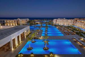 Luftaufnahme des Steigenberger Resort Alaya mit beleuchtetem Swimmingpool und Sonnenliegen