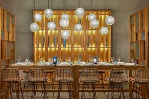 Speisesaal im Steigenberger Resort Alaya mit langen Holztischen, hängenden Lampen und rustikalen Stühlen.