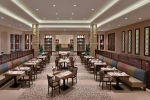 Innenansicht des Restaurants im Steigenberger Resort Alaya mit bunten Sitzbänken und Tischen.