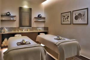 Spa-Behandlungsraum im Steigenberger Resort Alaya mit zwei Behandlungstischen, Tischdekorationen und gerahmten Bildern an der Wand.