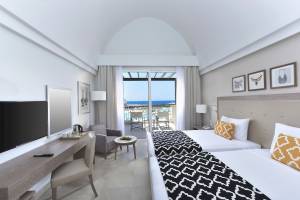 Zimmer im Steigenberger Resort Alaya mit zwei Betten, Schreibtisch und Aussicht auf den Ozean.