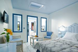 Doppelzimmer im Mitsis Cretan Village Hotel mit blauen Akzenten und weißen Möbeln.