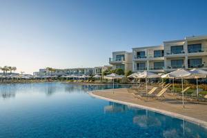 Außenpoolbereich des Asterias Beach Resorts mit Loungestühlen und Sonnenschirmen.
