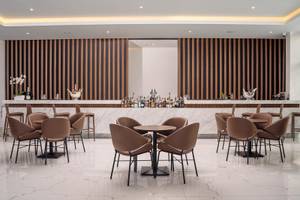 Innenansicht der Bar im Lindos Grand Resort & Spa Hotel mit gemusterten Wänden und modernen Möbeln.