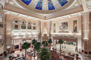 Innenansicht der Lobby des Palm Royale Soma Bay Hotels mit hoher Decke und bunten Glasmalereien.