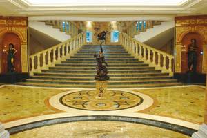 Lobby des Palm Royale Soma Bay Hotels mit einem zentralen Brunnen und zwei Statuen an den Seiten.
