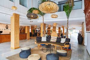 Lobby des Fergus Style Bahamas Hotels mit modernen Möbeln, Palmen und dekorativen Lampen.