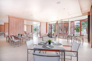 Innenbereich des Restaurants im Barcelo Mussanah Resort mit modernen Möbeln und Panoramafenstern.