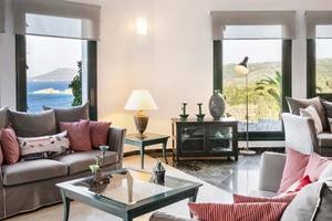 Wohnzimmer im Kalidon Panorama Hotel mit Meerblick, großen Fenstern und modernen Möbeln.