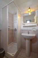 Badezimmer mit Duschkabine und Waschbecken im Naxos Resort Beach Hotel