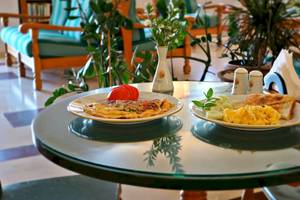 Frühstückstisch im Proteas Hotel mit Rührei, Gemüse und Toast.