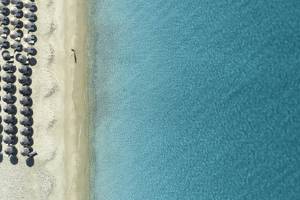 Luftaufnahme des Lagos Mare Hotels mit vielen Sonnenschirmen am Strand und blauem Wasser.