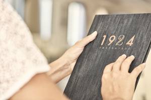 Frau hält ein Buch des 1924 Restaurants in den Händen.