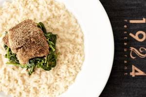Essenteller mit Reis, Spinat und gebratenem Fisch im Lagos Mare Hotel.