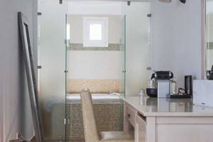 Innenansicht eines Badezimmers im Lagos Mare Hotel mit Badewanne und Schreibtisch.