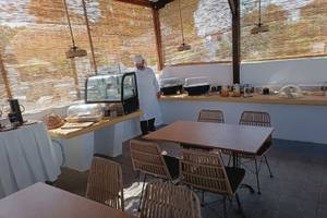 Ein Café im Naxos Summerland Resort mit einem Koch, der einen Kühlschrank öffnet.