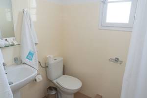 Badezimmer im Amaryllis Paros Beach Hotel mit Toilette, Waschbecken und Spiegel.