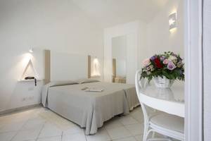Schlafzimmer im Mare Pineta Hotel mit zwei Betten und einem Tisch mit Blumen