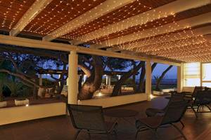 Terrasse im Mare Pineta Hotel bei Nacht mit beleuchteten Lampen und Möbeln.