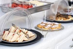 Frühstücksbuffet im Iris Boutique Hotel mit Sandwiches, Früchten und Waffeln.
