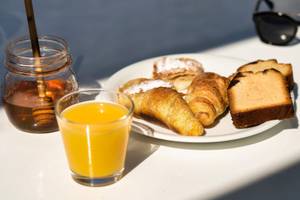 Frühstück im Iris Boutique Hotel mit Croissants, Toast und Orangensaft