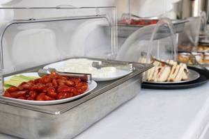 Frühstücksbuffet im Iris Boutique Hotel mit Tomaten, Käse und Sandwiches.